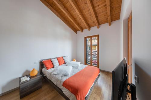 een slaapkamer met een bed met een oranje deken bij Appartamento Le Vele - BGL in Sirmione