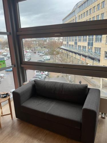 un sofá sentado frente a una gran ventana en Central apartment, en Dresden