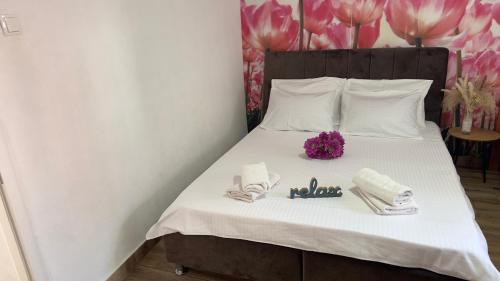 a bedroom with a bed with towels and purple flowers at Villa Zigana in Mostar