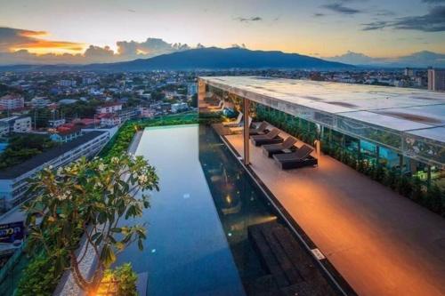 een gebouw met een zwembad voor een stad bij The Astra Luxury Condo in Town in Chiang Mai