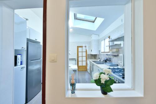 une cuisine avec une fenêtre et un vase de fleurs dans l'établissement Cozy appartment near Stade de France, à Saint-Denis