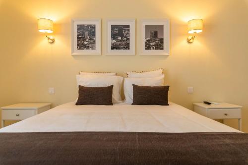 - une chambre avec un grand lit blanc et deux lumières dans l'établissement Douro Mool Guest House, à Lamego
