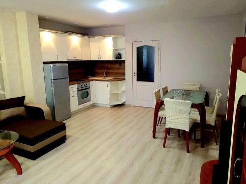 a small kitchen and living room with a table and chairs at Lux Apartment Sisi in Burgas