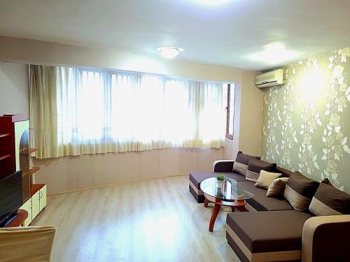 a living room with a couch and a large window at Lux Apartment Sisi in Burgas City