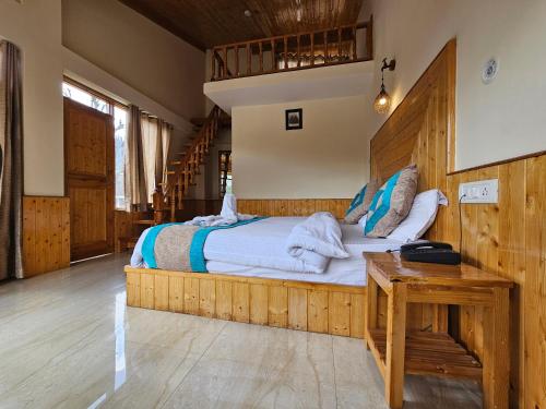 una camera con un grande letto con testiera in legno di Purnima Guest House a Manāli