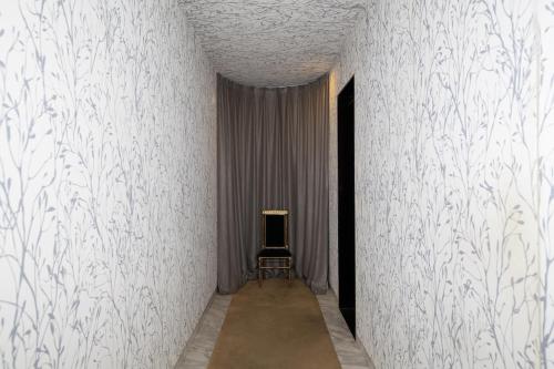 a corridor with a chair in a room with white walls at Gangnam Boutique Hotel Sohsul in Seoul