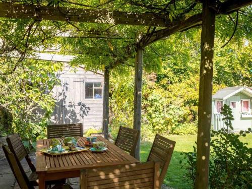 a wooden table and chairs under a pergola at Hope Cottage in Moreton in Marsh