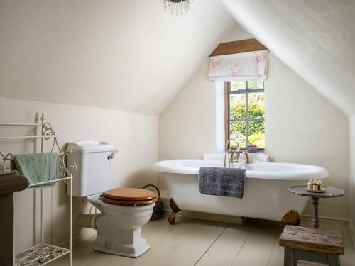 La salle de bains est pourvue de toilettes et d'une baignoire. dans l'établissement Hope Cottage, à Moreton-in-Marsh