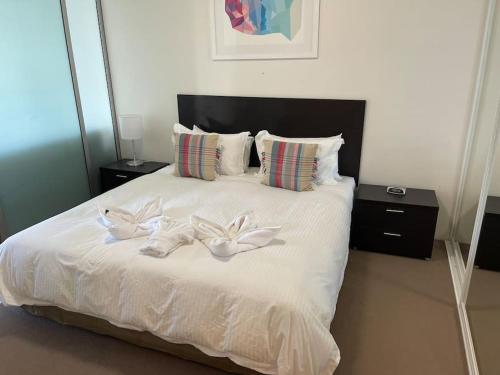 um quarto com uma cama com duas flores brancas em Stunning Water View Apartment - Pool, Gym, Sauna. em Cairns