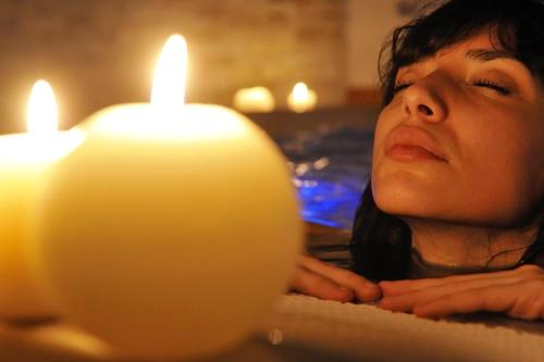 a woman is looking at two candles at Piccolo Hotel Aurora in Abbadia San Salvatore