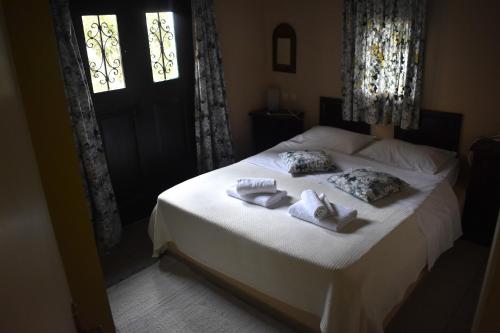 a bedroom with a bed with towels on it at Anemos Holiday Houses - Unterkunft in Südkreta in Keratokampos