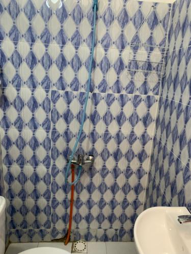 ein Badezimmer mit einer blau-weißen Wand in der Unterkunft chambre simple et confortable a ngor in Ngor