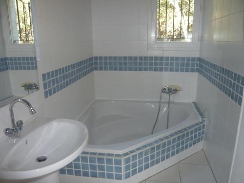 une salle de bain avec une baignoire et un lavabo dans l'établissement Maison dans les bois, à Sardan