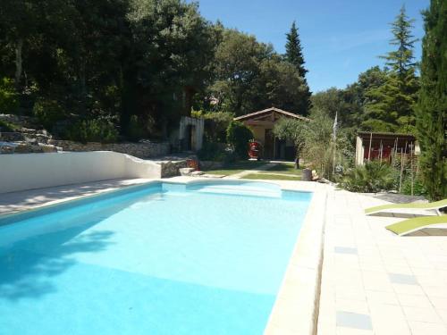 une grande piscine bleue dans une cour dans l'établissement Maison dans les bois, à Sardan