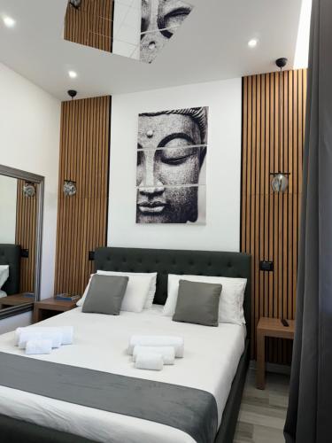 a bedroom with a bed with a black and white picture at Aragon Cottage Apartments in Le Castella