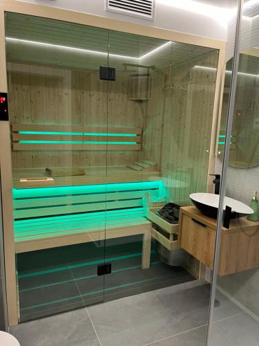 a bathroom with a glass shower with a sink at Apartament Kamienna 28 z prywatną sauną in Wisła