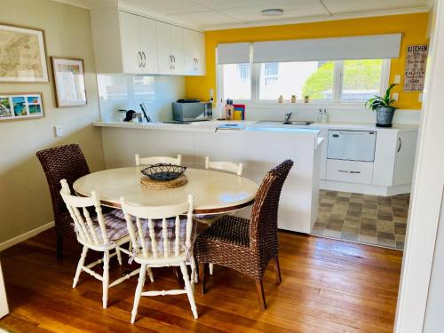 a kitchen with a dining room table and chairs at Rosedale Retreat in Invercargill