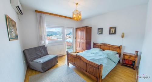 - une chambre avec un lit, une chaise et une fenêtre dans l'établissement Apartment Ado, à Mostar