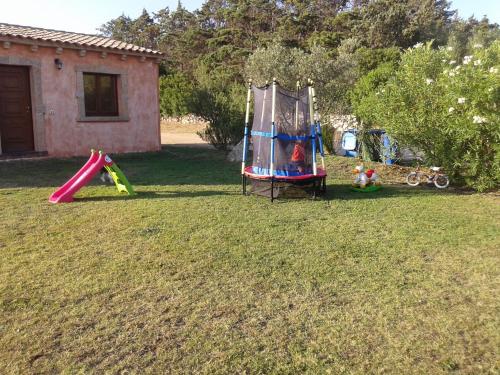 a yard with two play equipment in the grass at B&B Pubulos in Olbia