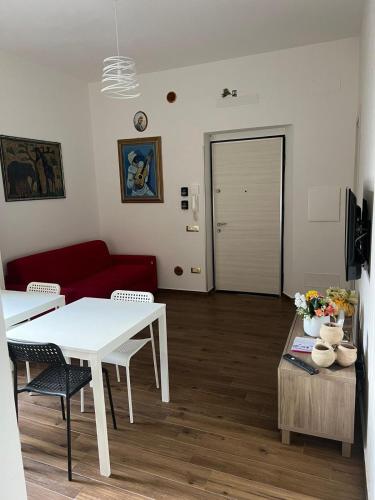 a living room with a white table and a red couch at L’Angolo degli Etruschi in Salerno