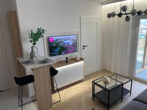 een woonkamer met een flatscreen-tv op een kast bij Imperial Citi Apartament in Krakau