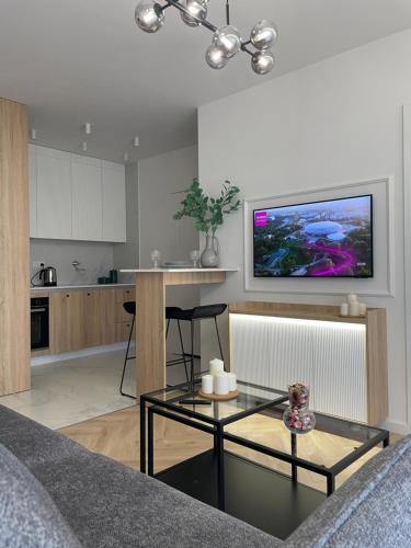 a living room with a table and a kitchen at Imperial Citi Apartament in Kraków