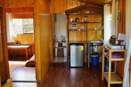 a kitchen with wooden walls and a wooden floor at Eco Lodge Cabañas con Piscina in Urubamba