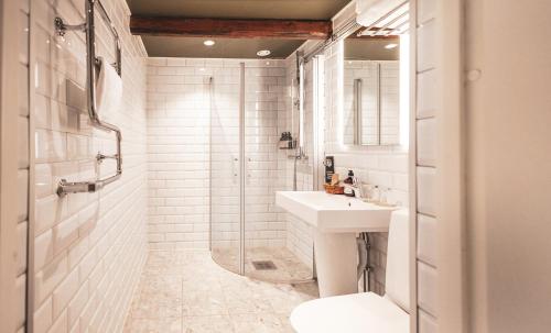 a white bathroom with a sink and a shower at Hotell Borgholm in Borgholm