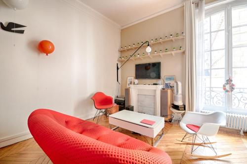 - un salon avec un canapé et des fauteuils rouges dans l'établissement Studio Loft des Combes - Welkeys, à Paris