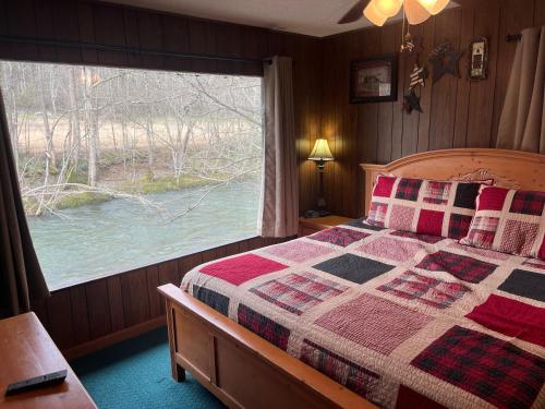 a bedroom with a bed and a large window at Riversong in Sevierville