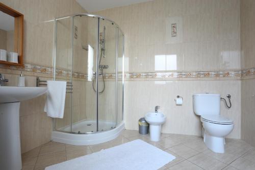 a bathroom with a shower and a toilet and a sink at Plaża Apartament in Ustronie Morskie