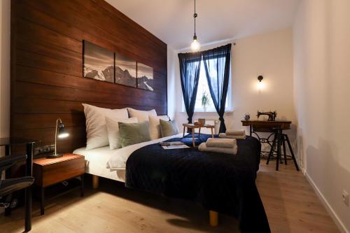 a bedroom with a large bed with a wooden headboard at Six Dreams Spot in Poznań