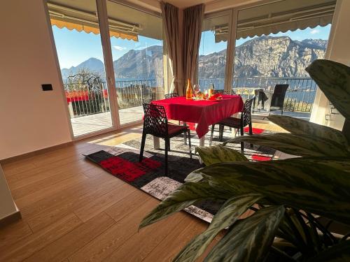een eetkamer met een rode tafel en stoelen en bergen bij Villalvento in Brenzone sul Garda