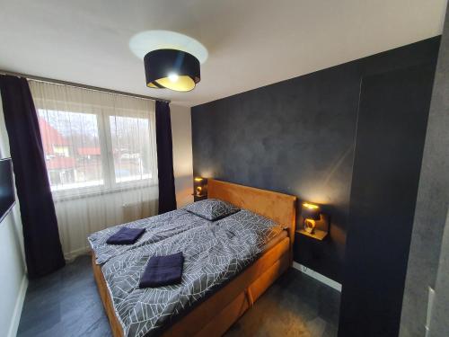 sypialnia z łóżkiem i dwiema poduszkami w obiekcie Black Brothers Wellness Apartments w Siófoku