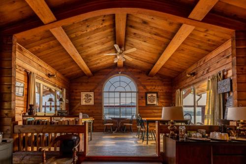 uma sala de jantar com tectos em madeira e uma grande janela em Alert Bay Lodge em Alert Bay