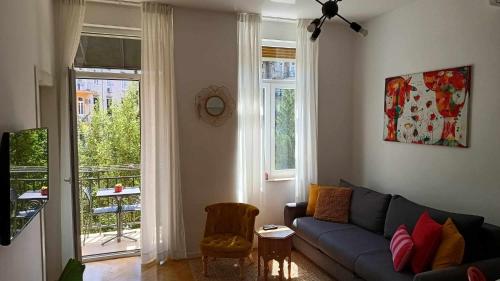 un soggiorno con divano blu e finestra di Apartments ART a Fiume (Rijeka)