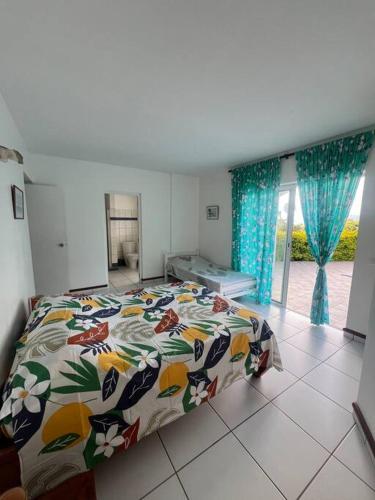 a bedroom with a bed with a colorful comforter at Te Tai Marama in Uturoa