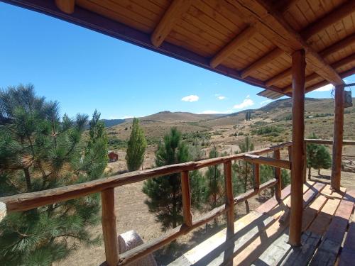 a view from the deck of a house with mountains in the background at Complejo La Soplada Hostel&Cabañas in Aluminé