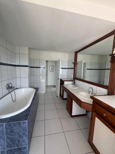 a bathroom with two sinks and a tub and mirrors at Te Tai Marama in Uturoa