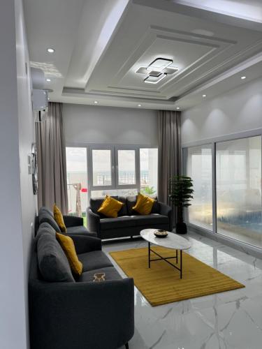 a living room with two couches and a table at Sea View Chalet Al Ashkharah in Al Ashkharah