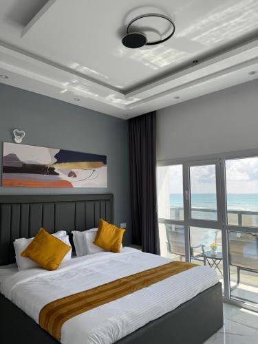 a bedroom with a bed with a view of the ocean at Sea View Chalet Al Ashkharah in Al Ashkharah