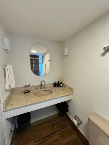a bathroom with a sink and a mirror at Flat Saint Paul Retro in Brasilia