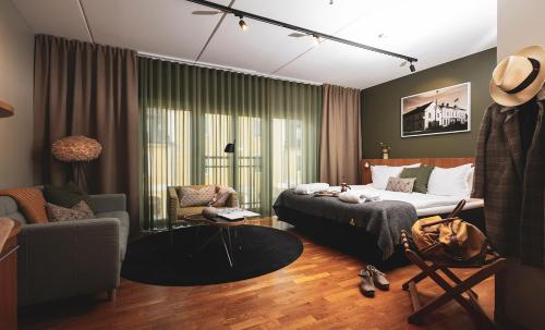 Hotell Borgholm في بورغولم: غرفة نوم مع سرير وغرفة معيشة