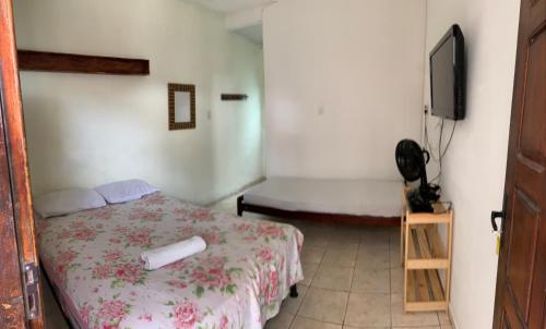 Suítes Mar Azul في أراكاجو: غرفة نوم فيها سرير وتلفزيون