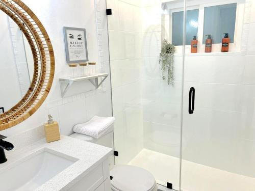 a bathroom with a shower and a toilet and a sink at Stylish Heated Pool House Near The Beach in St. Petersburg