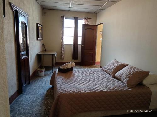 Antigua Sweet Apartment في أنتيغوا غواتيمالا: غرفة نوم بسرير ونافذة وباب