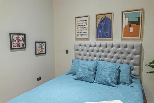 a bedroom with a bed with blue pillows at Royal Living Poblado in Medellín