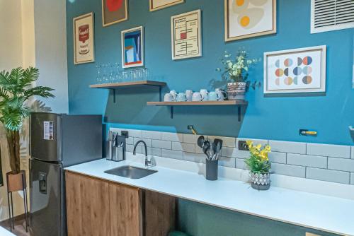 a kitchen with a sink and a blue wall at Royal Living Poblado in Medellín