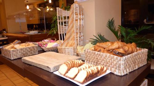 una mesa cubierta con cestas de pan y bollería en Central Hotel en Créteil