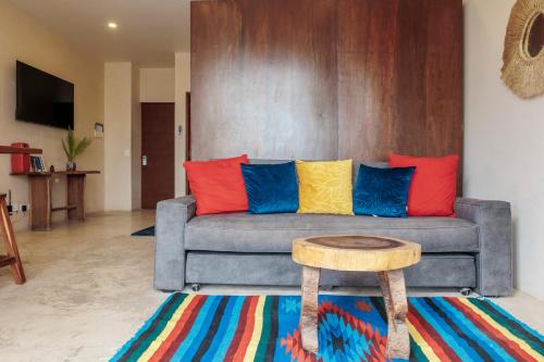 a living room with a couch with colorful pillows at 2 FREE BICYCLES BEAUTIFUL SUIT NEAR THE SEA BEAUTIFUL POOl in Tulum